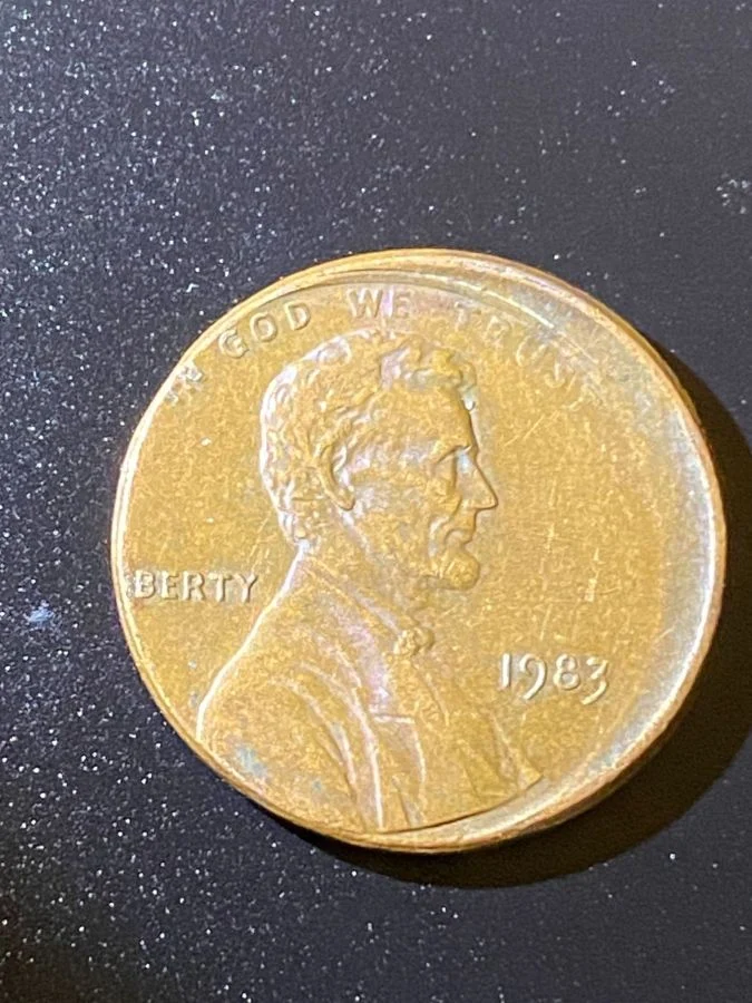 1983 penny off-center strike with visible blank crescent and date visible